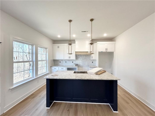 kitchen featuring white cabinets, baseboards, visible vents, and backsplash