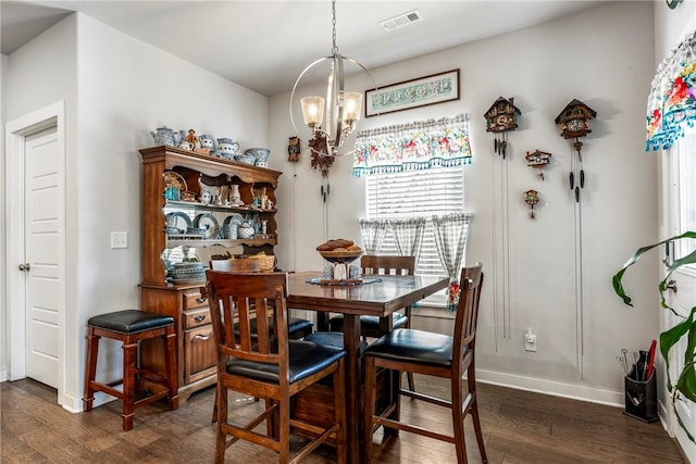 dining space featuring visible vents, baseboards, dark wood-type flooring, and an inviting chandelier