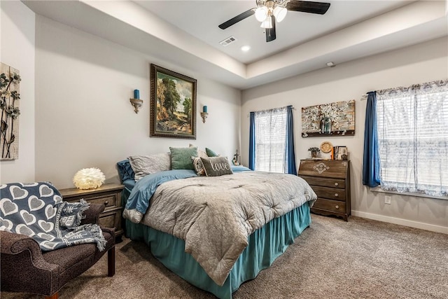 carpeted bedroom with visible vents, baseboards, ceiling fan, a tray ceiling, and recessed lighting