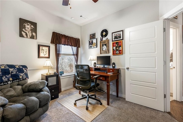 carpeted office space featuring visible vents, baseboards, and a ceiling fan