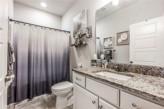 bathroom featuring vanity, curtained shower, toilet, and visible vents