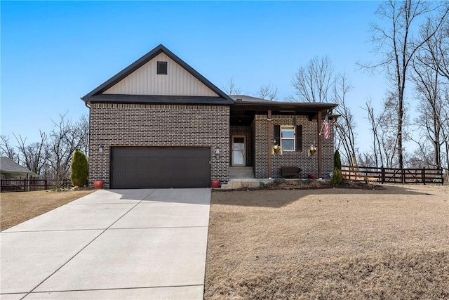 view of front of home with brick siding, concrete driveway, and fence