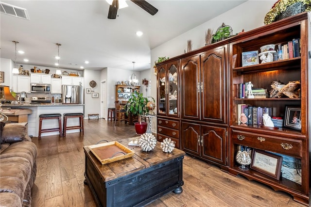 living area featuring recessed lighting, visible vents, wood finished floors, and a ceiling fan