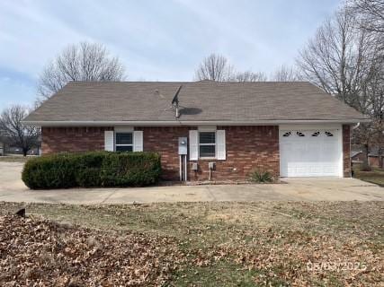 ranch-style house with a garage, brick siding, and driveway