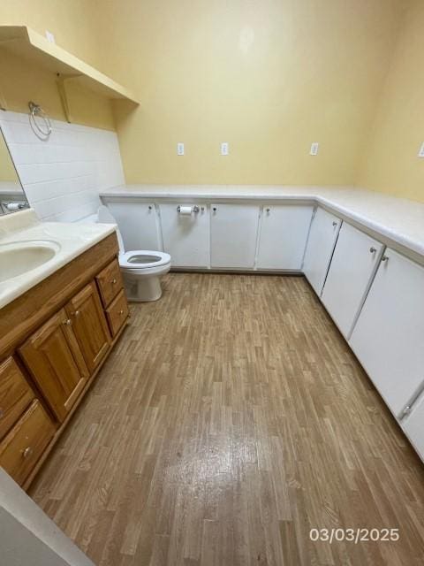 bathroom with vanity, toilet, and wood finished floors