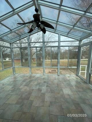 unfurnished sunroom featuring a ceiling fan