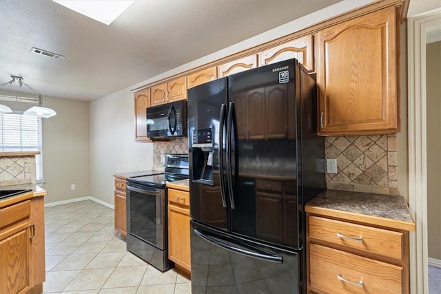 kitchen with visible vents, black appliances, backsplash, light tile patterned floors, and baseboards