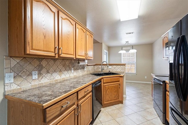 kitchen with tasteful backsplash, light tile patterned floors, a peninsula, black appliances, and a sink