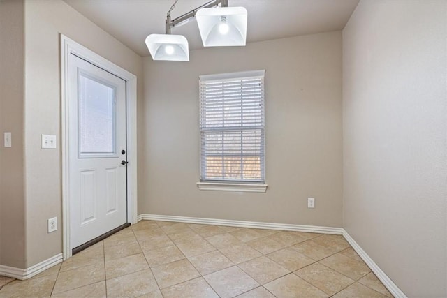 interior space featuring light tile patterned flooring and baseboards