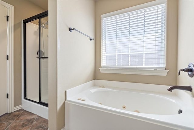 full bath with tile patterned floors, a tub with jets, and a stall shower