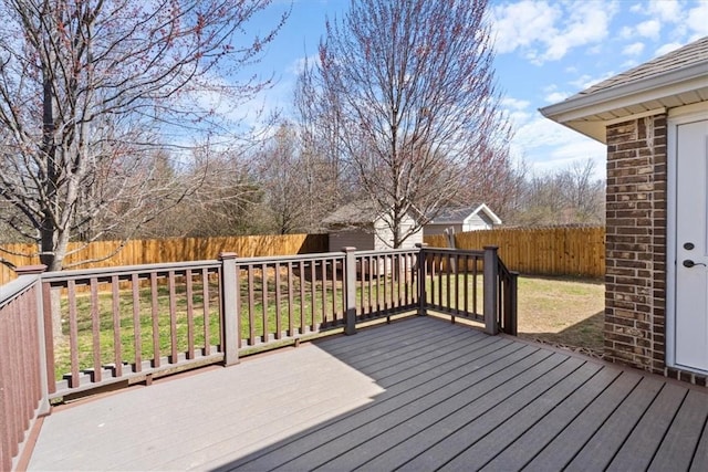 wooden terrace with a lawn and a fenced backyard