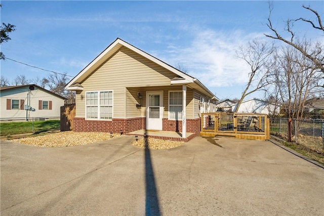 bungalow with fence, brick siding, and driveway