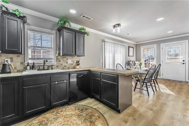 kitchen with visible vents, a peninsula, a sink, black dishwasher, and light wood-type flooring