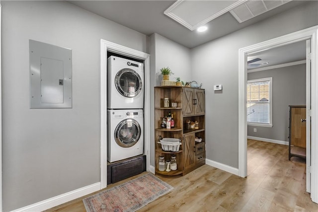 laundry area with visible vents, stacked washing maching and dryer, laundry area, electric panel, and light wood-style floors