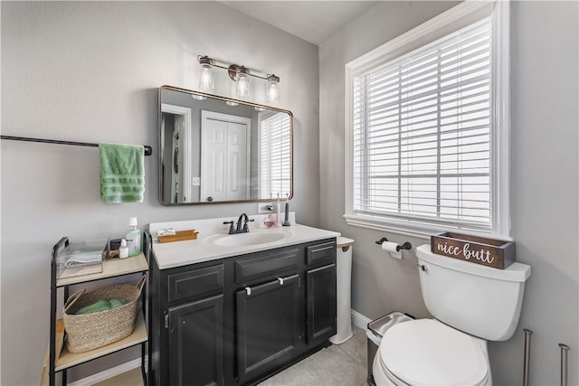 half bathroom with tile patterned flooring, toilet, vanity, and baseboards