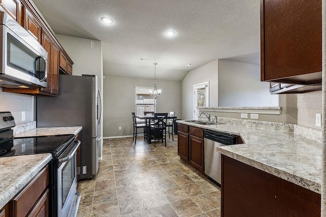 kitchen with a sink, appliances with stainless steel finishes, a peninsula, and light countertops