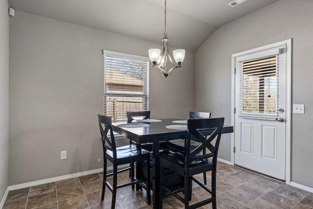 dining space featuring an inviting chandelier, baseboards, and lofted ceiling