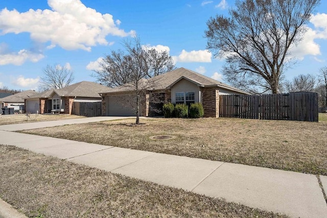 ranch-style house with an attached garage, fence, brick siding, and driveway