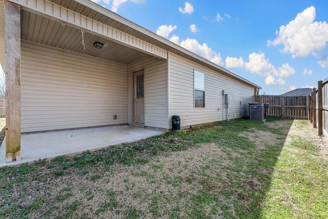 back of property featuring cooling unit, a patio, a lawn, and fence