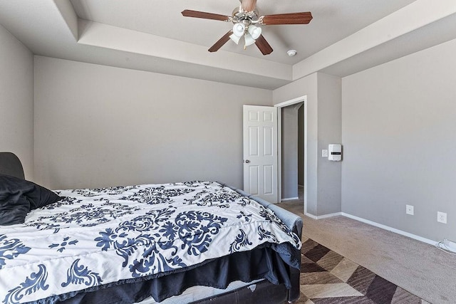 bedroom featuring carpet flooring, ceiling fan, a raised ceiling, and baseboards