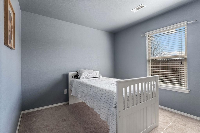 carpeted bedroom with baseboards and visible vents