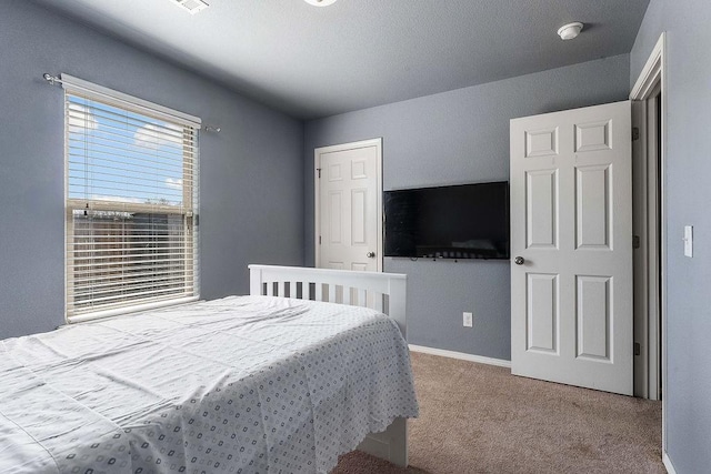 bedroom featuring baseboards and carpet