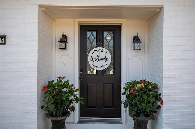 view of exterior entry with brick siding