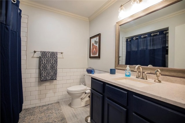 full bath featuring a wainscoted wall, toilet, vanity, ornamental molding, and tile walls