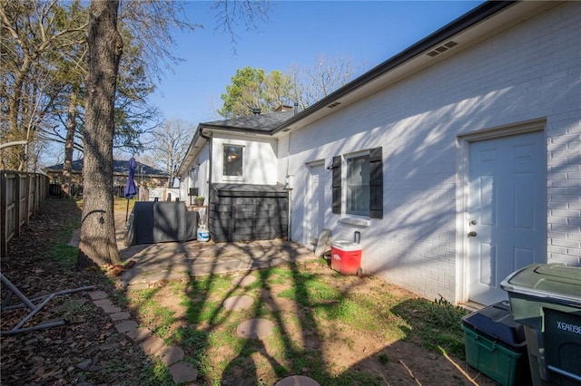 exterior space featuring a patio, fence, and brick siding