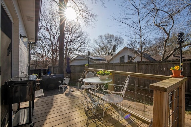 deck with outdoor dining area and a fenced backyard