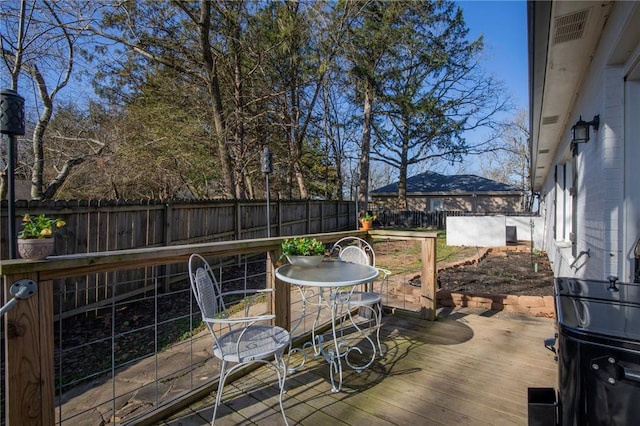 deck featuring outdoor dining area and a fenced backyard