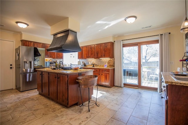 kitchen with visible vents, stainless steel refrigerator with ice dispenser, island exhaust hood, tasteful backsplash, and a center island