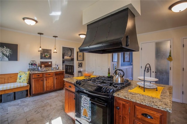 kitchen with brown cabinetry, gas stove, crown molding, and exhaust hood