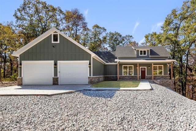 view of front facade with driveway, a porch, board and batten siding, a front yard, and an attached garage