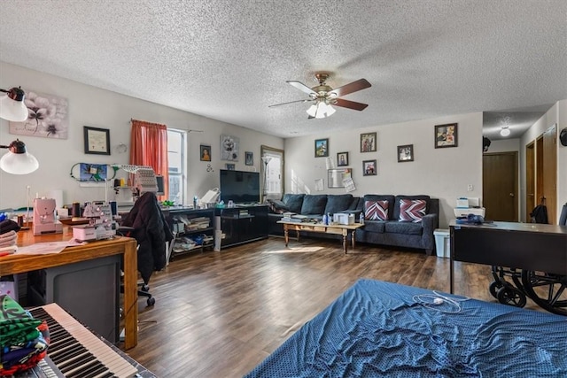 bedroom featuring ceiling fan, wood finished floors, and a textured ceiling