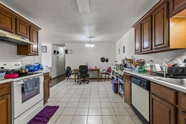 kitchen with under cabinet range hood, white appliances, light tile patterned floors, and light countertops