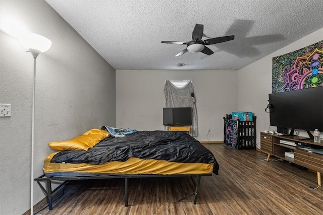 bedroom with ceiling fan, baseboards, a textured ceiling, and wood finished floors