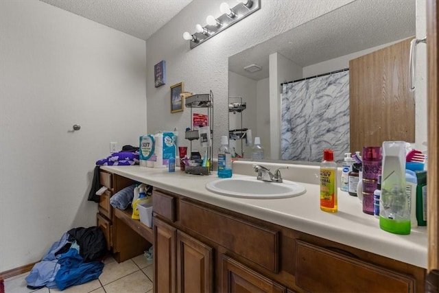 bathroom featuring tile patterned flooring, a shower with shower curtain, vanity, and a textured ceiling