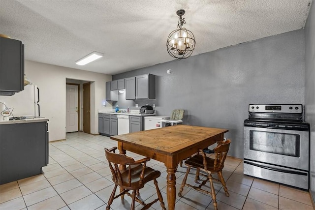 kitchen with a chandelier, light countertops, light tile patterned floors, gray cabinets, and white appliances