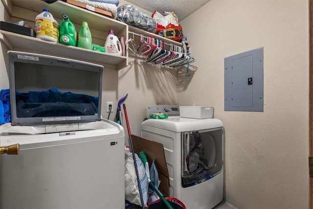 clothes washing area featuring electric panel, laundry area, washer and dryer, and a textured ceiling