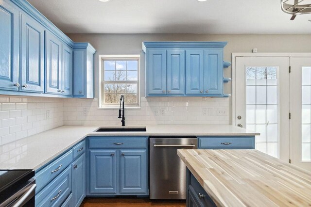 kitchen featuring tasteful backsplash, a sink, blue cabinetry, wood counters, and stainless steel dishwasher