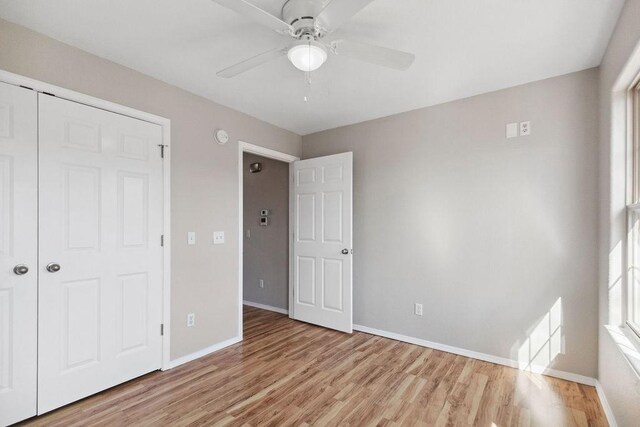 unfurnished bedroom with a ceiling fan, baseboards, and light wood finished floors