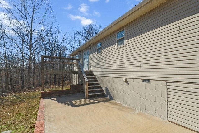 view of property exterior with a patio area and stairway