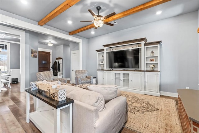 living area featuring beamed ceiling, recessed lighting, a ceiling fan, and wood finished floors