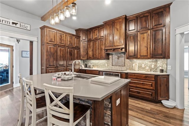 kitchen with tasteful backsplash, a kitchen bar, and a sink