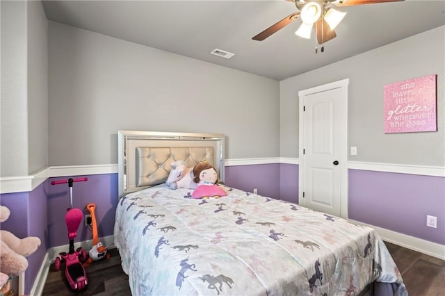 bedroom featuring visible vents, ceiling fan, baseboards, and wood finished floors