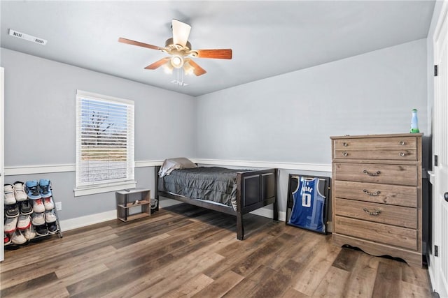 bedroom featuring visible vents, baseboards, dark wood-type flooring, and a ceiling fan