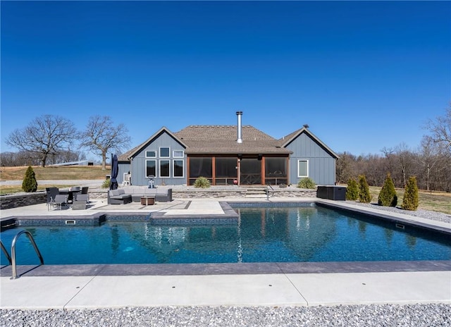 pool with a sunroom, outdoor lounge area, and a patio area