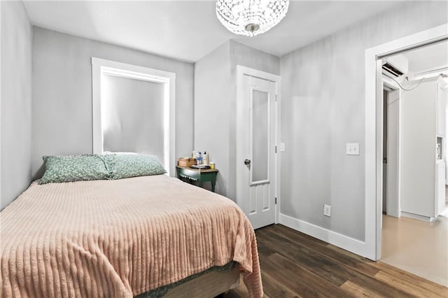 bedroom with dark wood-type flooring and baseboards