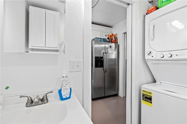 clothes washing area with a sink, laundry area, and stacked washing maching and dryer